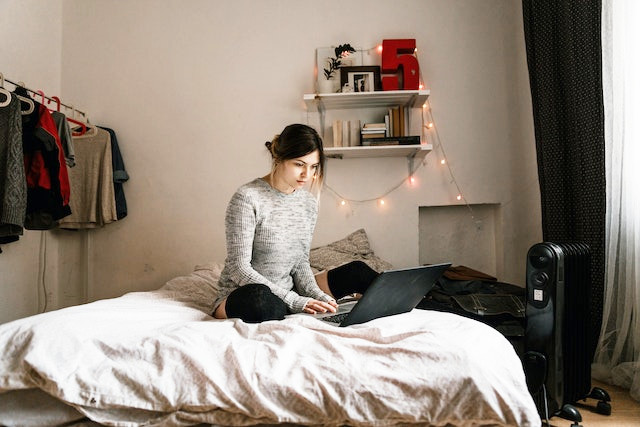 ベッドの上でパソコンする女性