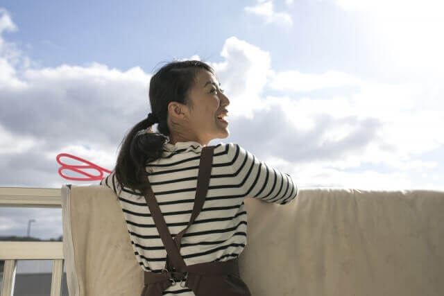 布団を干す女性