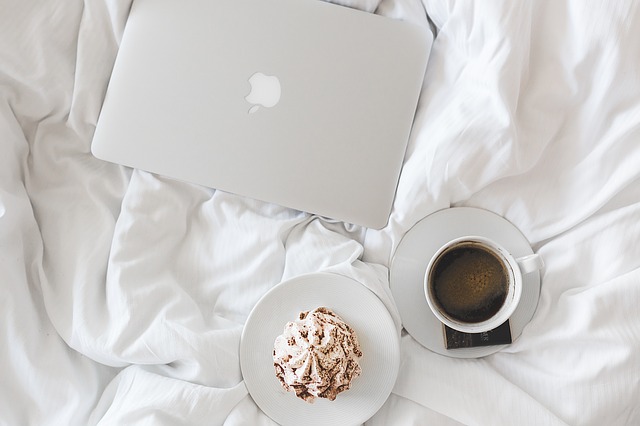 ベッドの上のPCとコーヒー