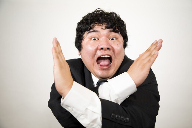 手で☓する男性