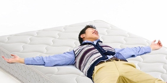 マットレスに寝て試す男性